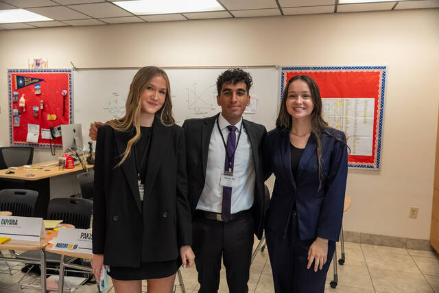 Three delegates standing together between committee sessions