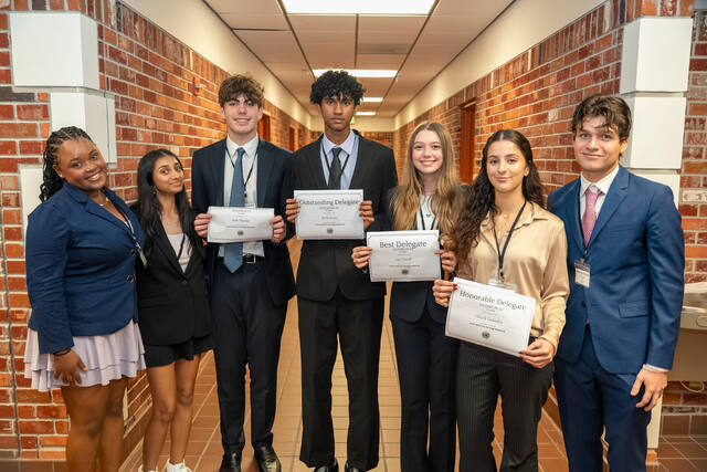 A Heritage delegation holding their certificates of recognition