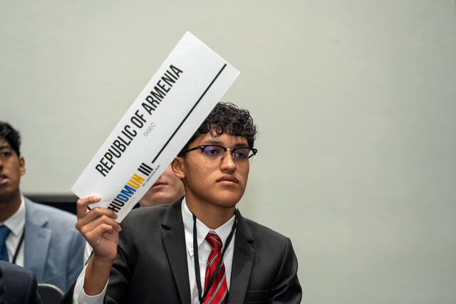 A delegate raising their placard to be recognized in committee